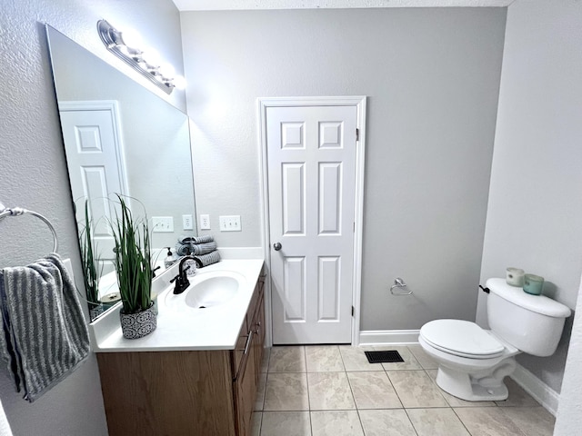 bathroom with vanity, toilet, baseboards, and tile patterned flooring