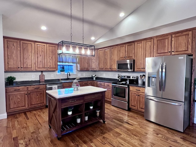 kitchen featuring brown cabinetry, appliances with stainless steel finishes, and a sink