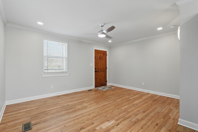 empty room featuring crown molding, visible vents, and light wood finished floors