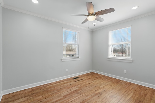 spare room featuring baseboards, ornamental molding, and light wood finished floors