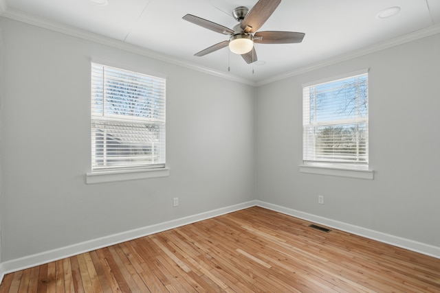 spare room with visible vents, a healthy amount of sunlight, light wood-type flooring, and ornamental molding