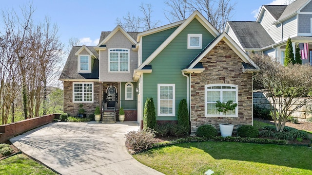 craftsman inspired home featuring stone siding, a front lawn, and fence