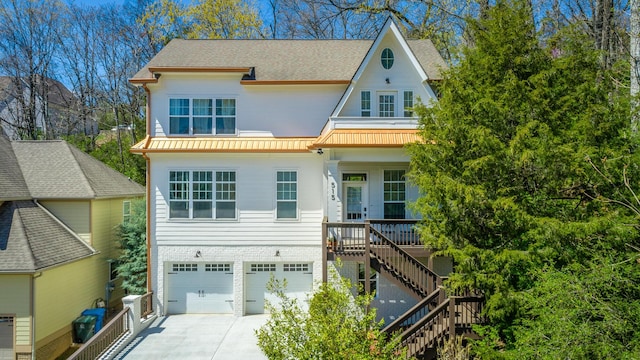 view of front facade with stairs, roof with shingles, concrete driveway, a garage, and a porch