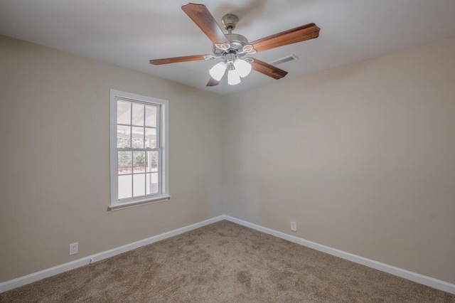 carpeted spare room featuring visible vents, ceiling fan, and baseboards