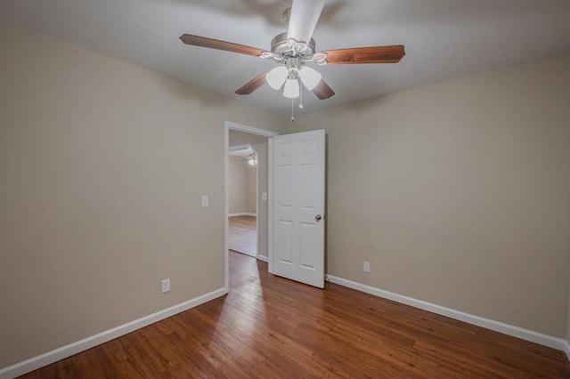 unfurnished room featuring baseboards, wood finished floors, and ceiling fan