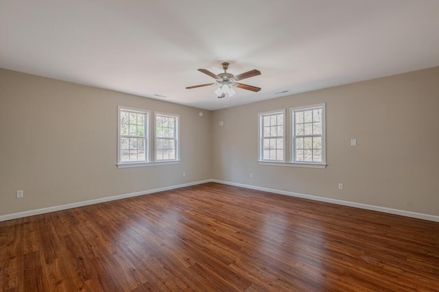 empty room with baseboards, wood finished floors, and a ceiling fan