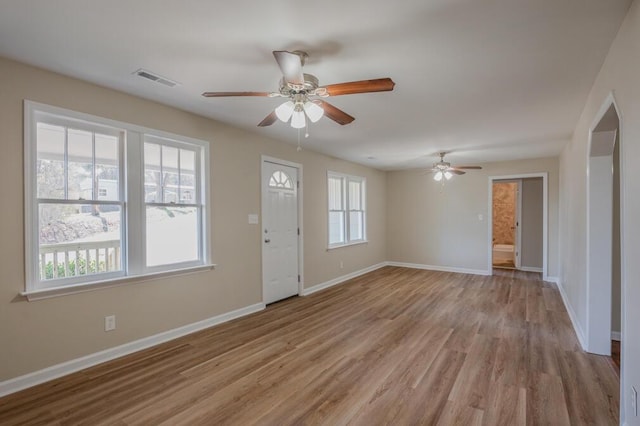 interior space with visible vents, baseboards, light wood-type flooring, and a ceiling fan