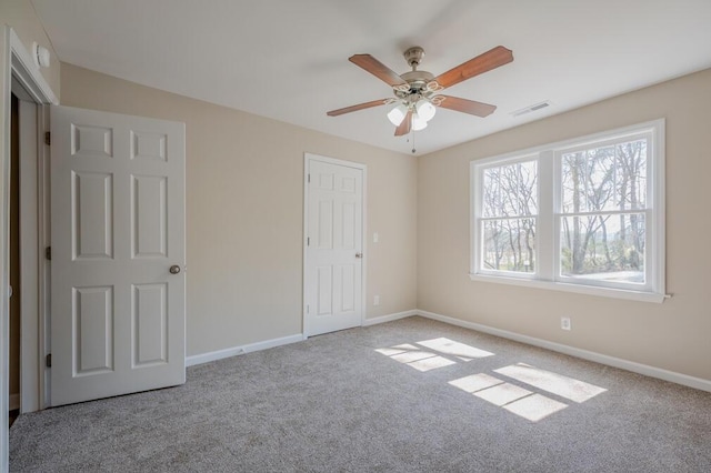 unfurnished bedroom with ceiling fan, carpet, visible vents, and baseboards