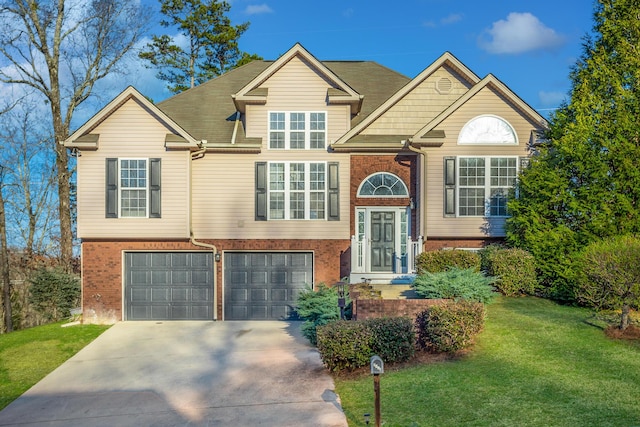 raised ranch with a garage, a front yard, brick siding, and driveway