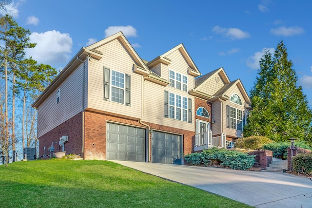 split foyer home with cooling unit, concrete driveway, a front yard, a garage, and brick siding