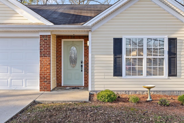 property entrance with a garage, brick siding, and a shingled roof