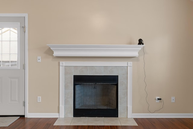 details with a fireplace, baseboards, and wood finished floors