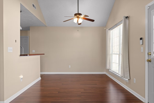 unfurnished room with visible vents, baseboards, dark wood-style floors, and vaulted ceiling