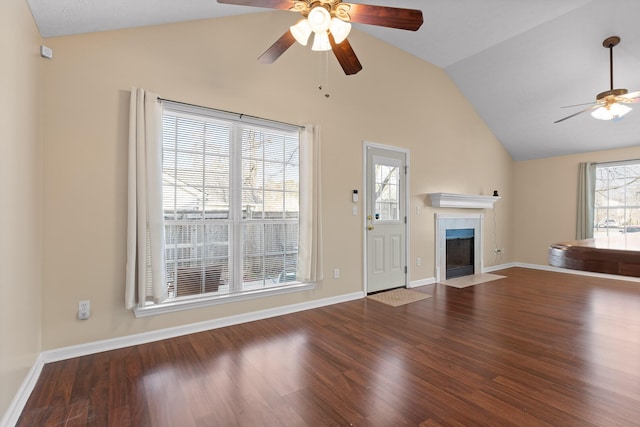 unfurnished living room with wood finished floors, ceiling fan, a fireplace, and vaulted ceiling