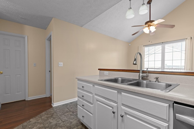 kitchen with dishwasher, vaulted ceiling, light countertops, and a sink