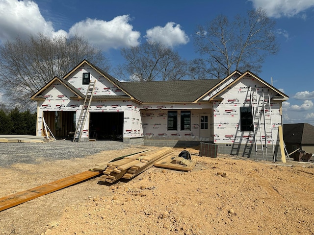 property in mid-construction featuring a garage and gravel driveway