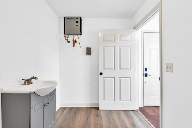 bathroom with vanity, wood finished floors, and baseboards