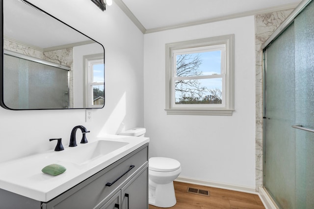 bathroom featuring visible vents, toilet, ornamental molding, wood finished floors, and a shower stall