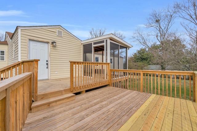 wooden deck with a lawn and a sunroom