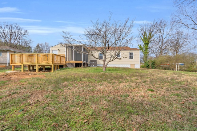 back of house featuring a lawn and a deck