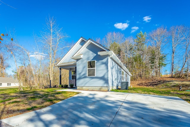 view of front of home with concrete driveway, central air condition unit, and board and batten siding