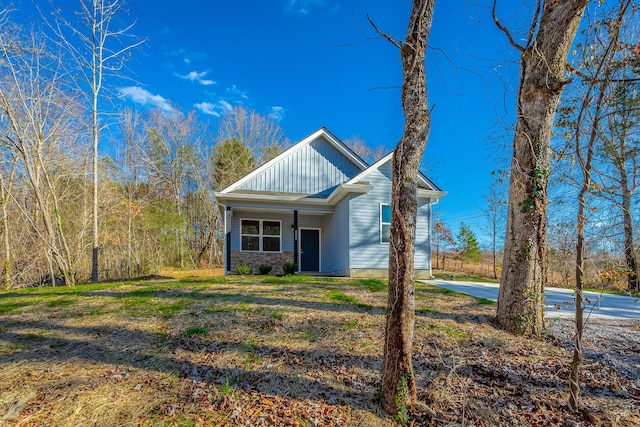 view of front facade featuring board and batten siding and a front yard