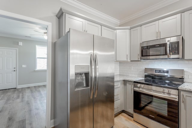 kitchen with a ceiling fan, tasteful backsplash, appliances with stainless steel finishes, and ornamental molding