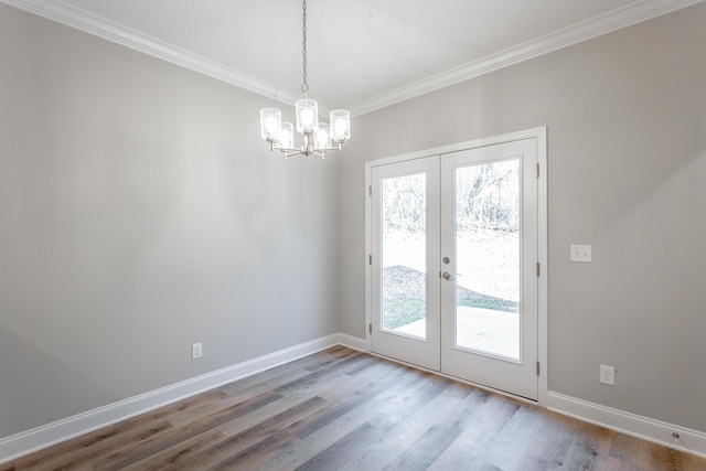 entryway with crown molding, baseboards, french doors, wood finished floors, and a notable chandelier