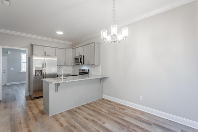 kitchen featuring backsplash, crown molding, light wood-type flooring, a peninsula, and stainless steel appliances