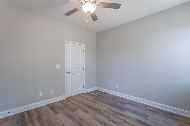 empty room featuring ceiling fan, baseboards, and wood finished floors