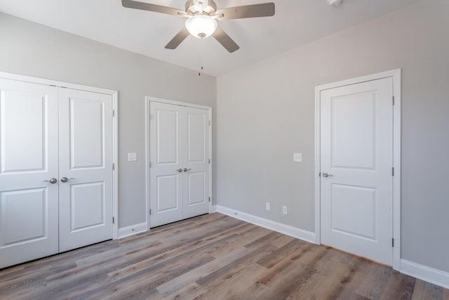 unfurnished bedroom with wood finished floors and baseboards