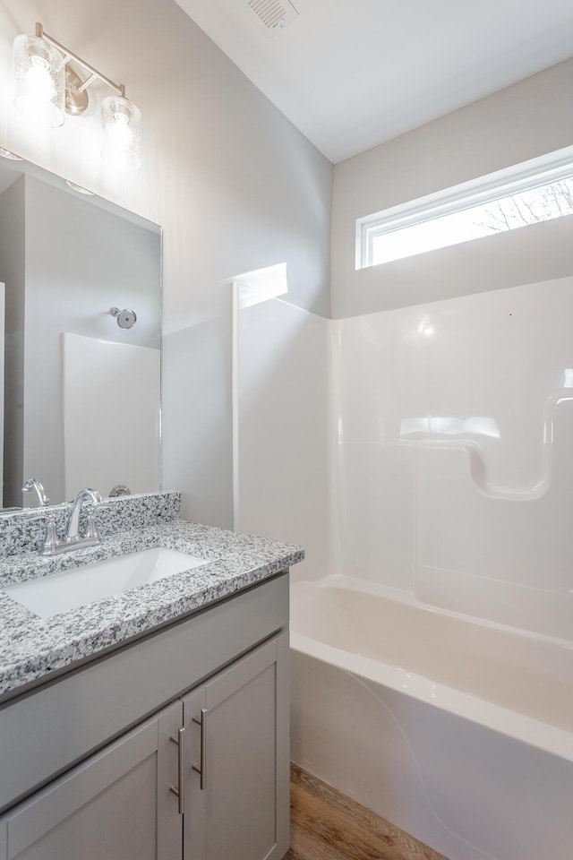 full bathroom with vanity, shower / bathing tub combination, and wood finished floors