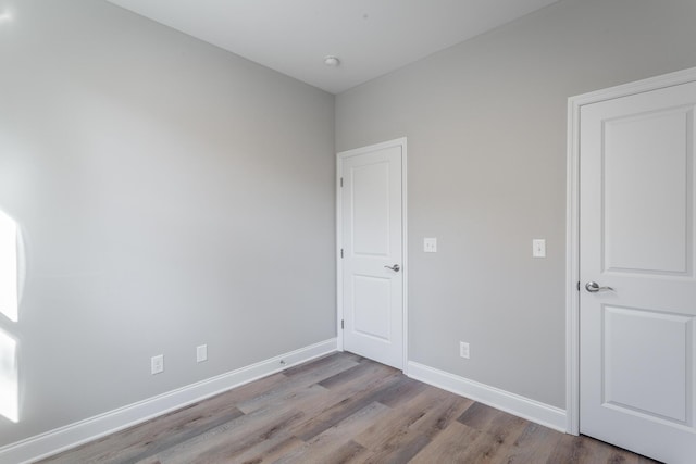 unfurnished room with wood finished floors and baseboards