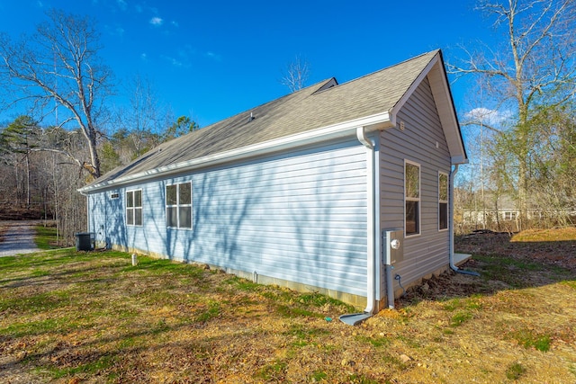 view of side of property featuring a yard and central AC unit