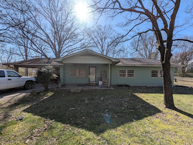 view of front of house featuring an attached carport and a front lawn