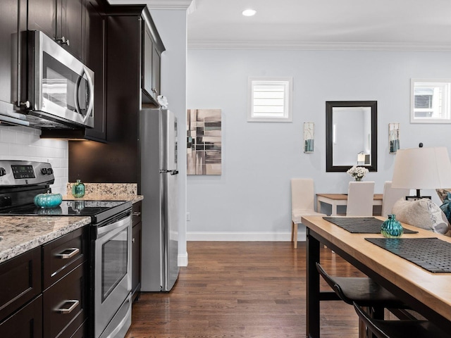 kitchen featuring decorative backsplash, crown molding, dark wood finished floors, and stainless steel appliances