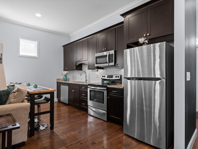 kitchen with dark wood-type flooring, ornamental molding, a sink, tasteful backsplash, and stainless steel appliances