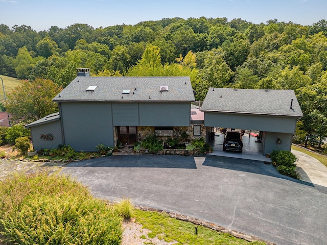 view of front facade with a view of trees and driveway