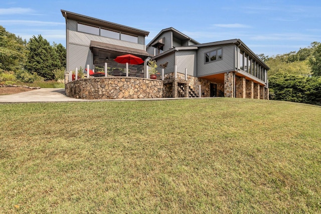 view of front of home with stairway, stone siding, and a front yard