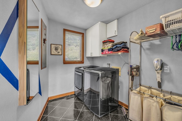 washroom featuring dark tile patterned flooring, cabinet space, independent washer and dryer, and baseboards