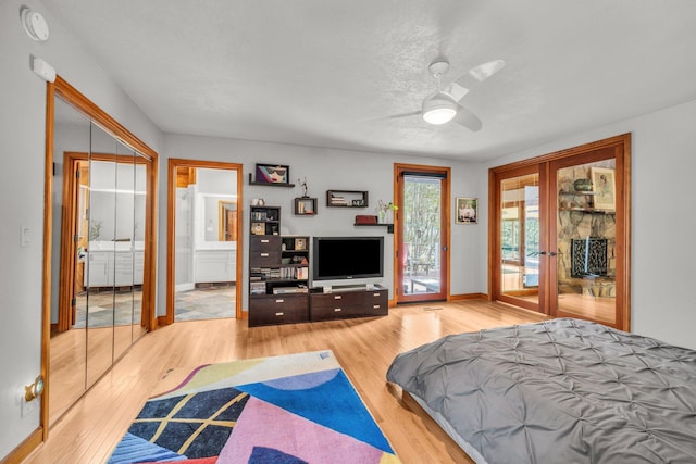 bedroom featuring access to exterior, ensuite bathroom, baseboards, and wood finished floors