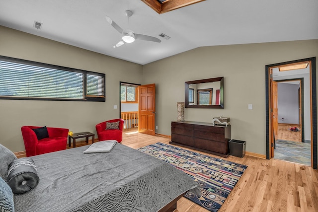 bedroom with visible vents, baseboards, lofted ceiling, and wood finished floors