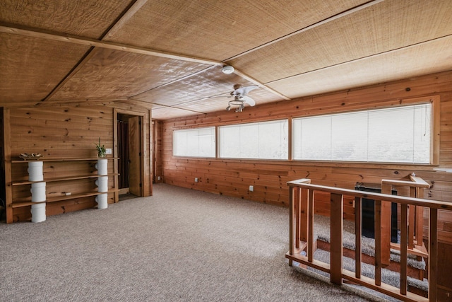 interior space with wooden walls, lofted ceiling, and carpet