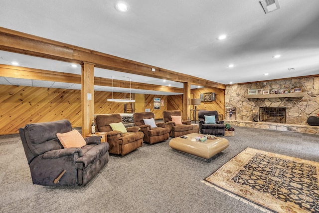 living room with a fireplace, wooden walls, carpet, and visible vents