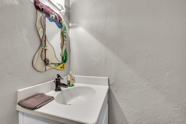 bathroom featuring vanity and a textured wall