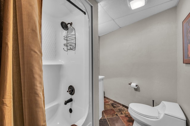 full bathroom featuring tile patterned flooring,  shower combination, toilet, and a drop ceiling