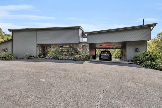 view of building exterior featuring an attached carport and driveway