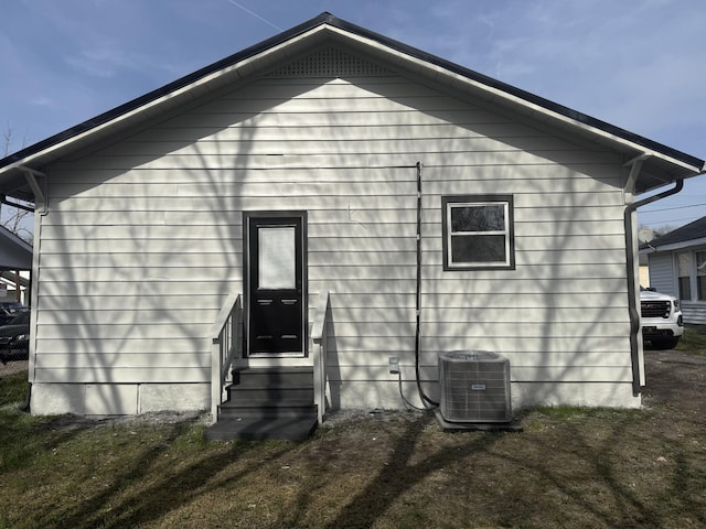 rear view of property featuring entry steps and central AC