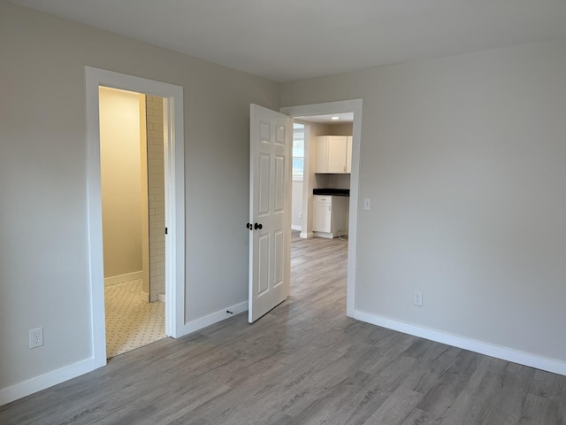 unfurnished bedroom with baseboards and wood finished floors