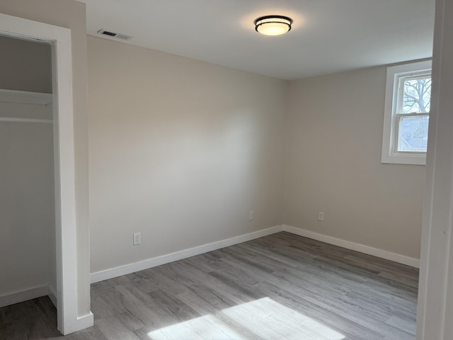 unfurnished bedroom with visible vents, baseboards, and wood finished floors